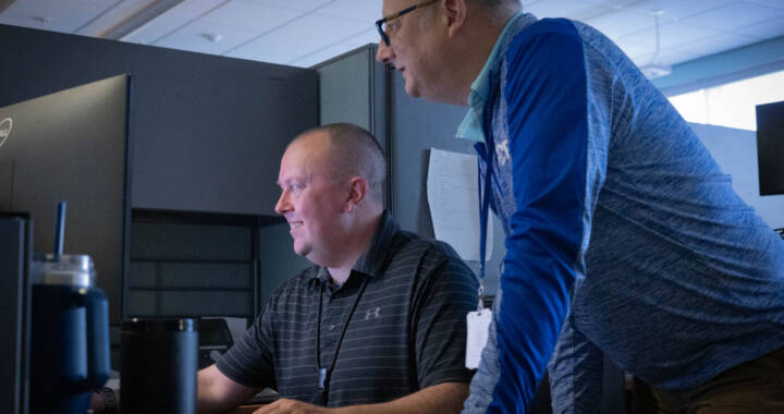 Two men looking at a computer screen in an office