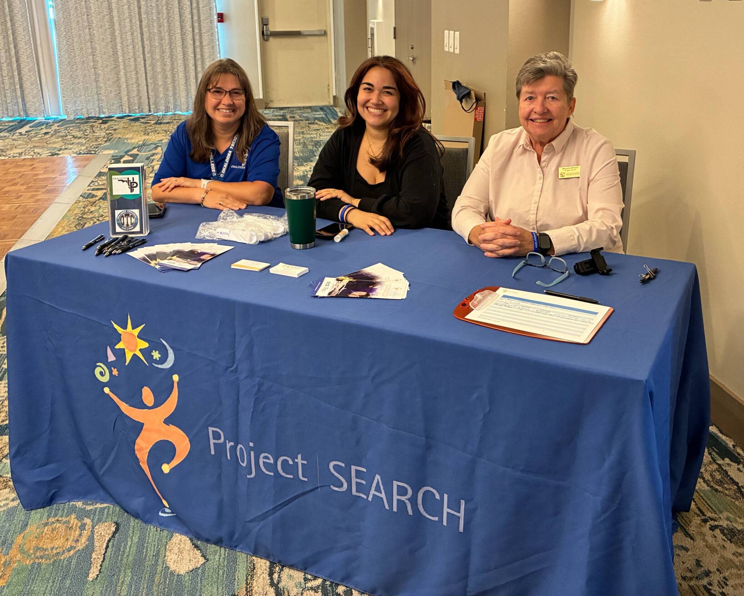 Project SEARCH representatives sitting behind the sign in table at a hiring event