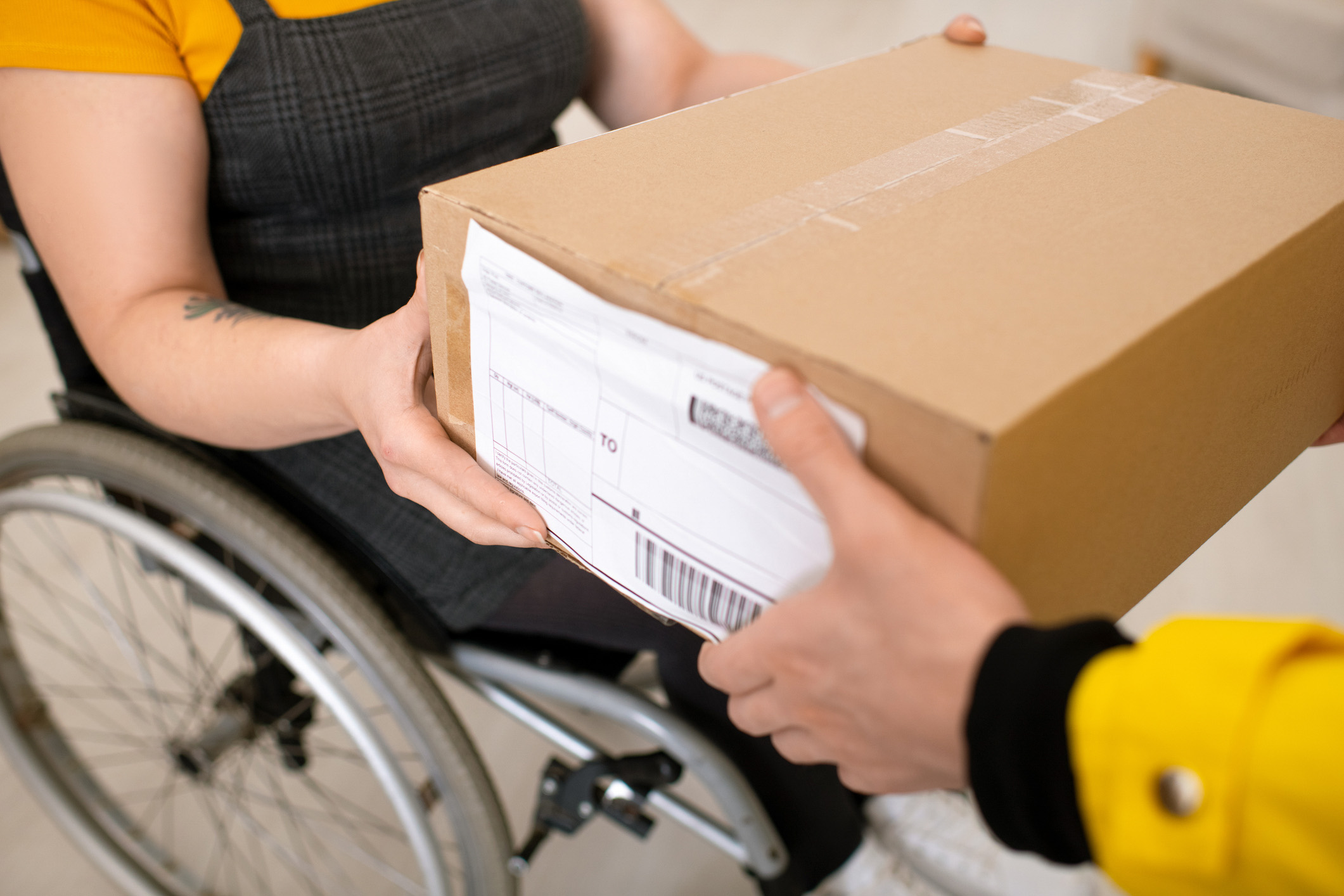disabled delivery person hands box to recipient