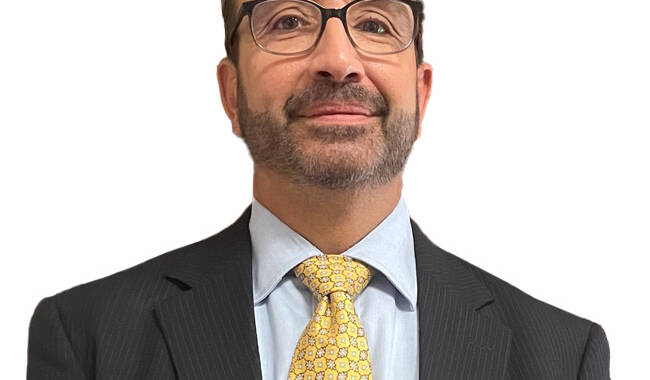 man with glasses wearing a suit and tie.