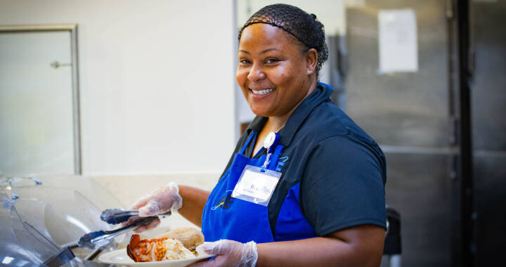 Woman dishing food onto a plate