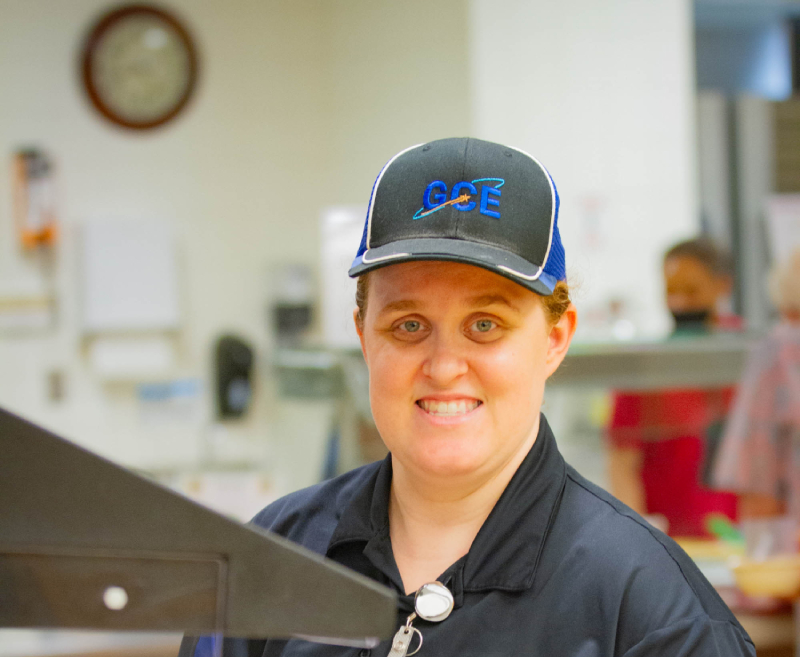 Food service worker prepping a plate in a serving line