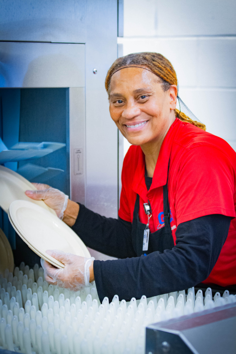 Woman loads dish for cleaning