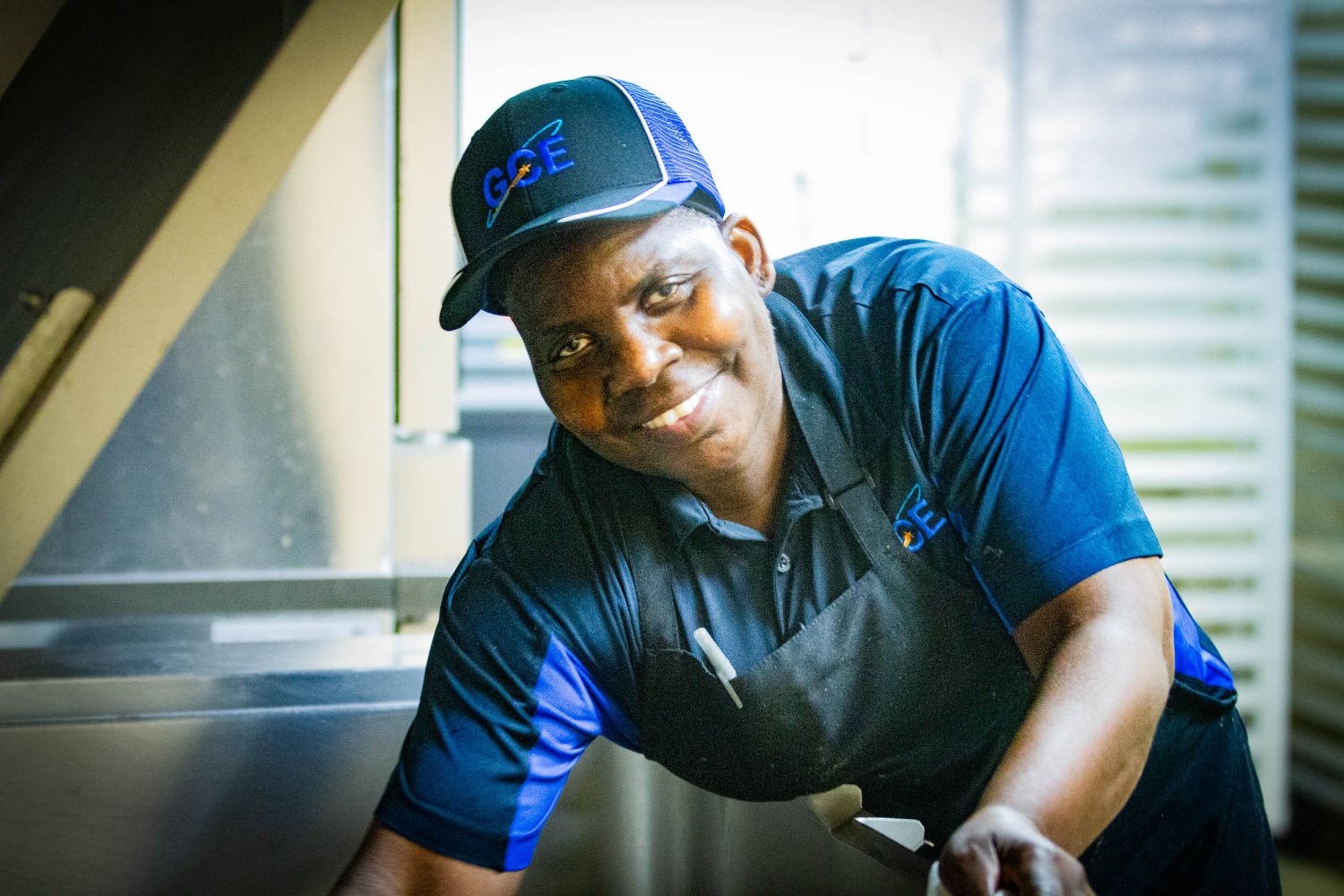 Food service worker cleans equipment in kitchen