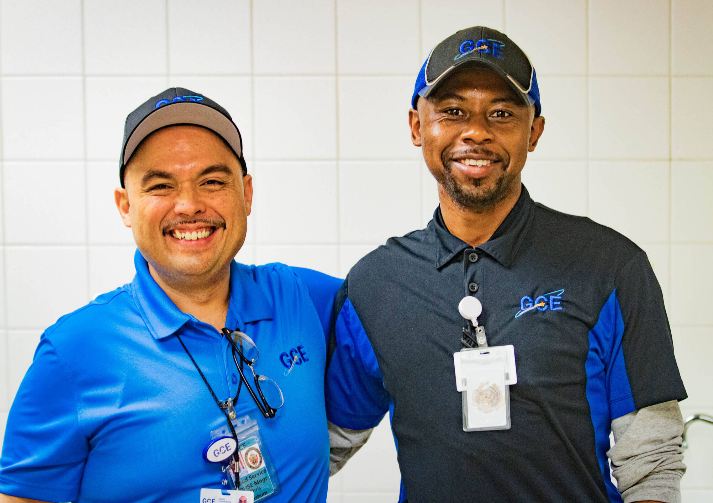 Two men in GCE uniforms posing to smile at the camera.