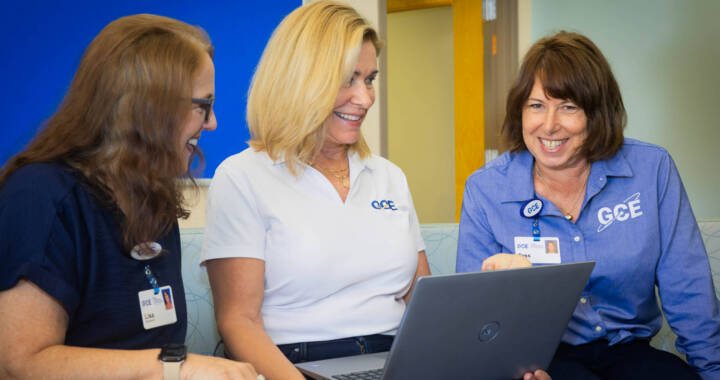 Employment support services team meeting gathered around laptop