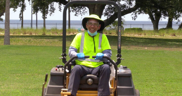 Facilities lawn team member smiling at camera