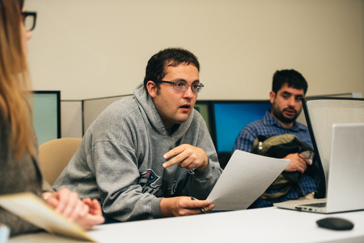 Adult woman and two men listening to training class in room of computers
