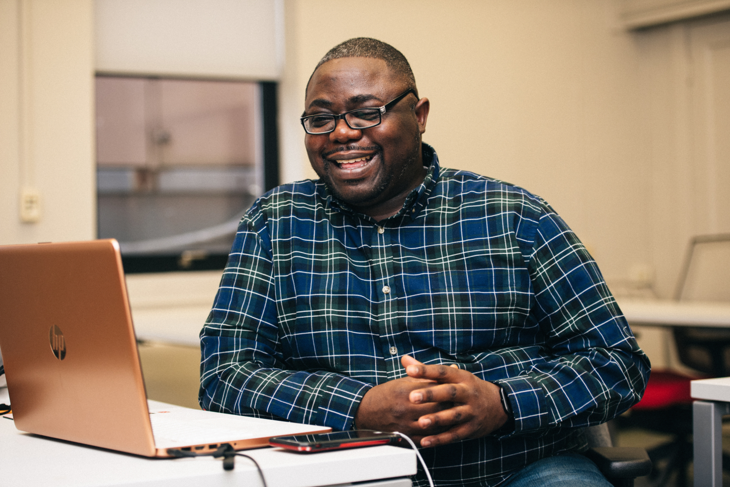 Man smiling, looking at laptop